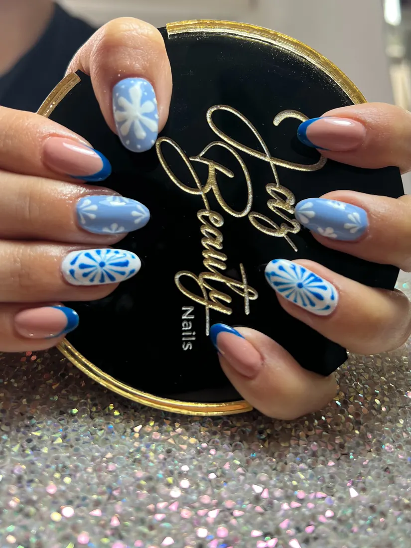 Diseño de uñas en azul con detalles blancos
